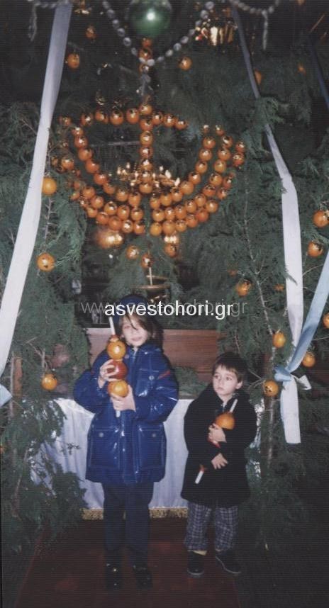 Παιδιά με κεριά στολισμένα με πορτοκάλια και μήλα